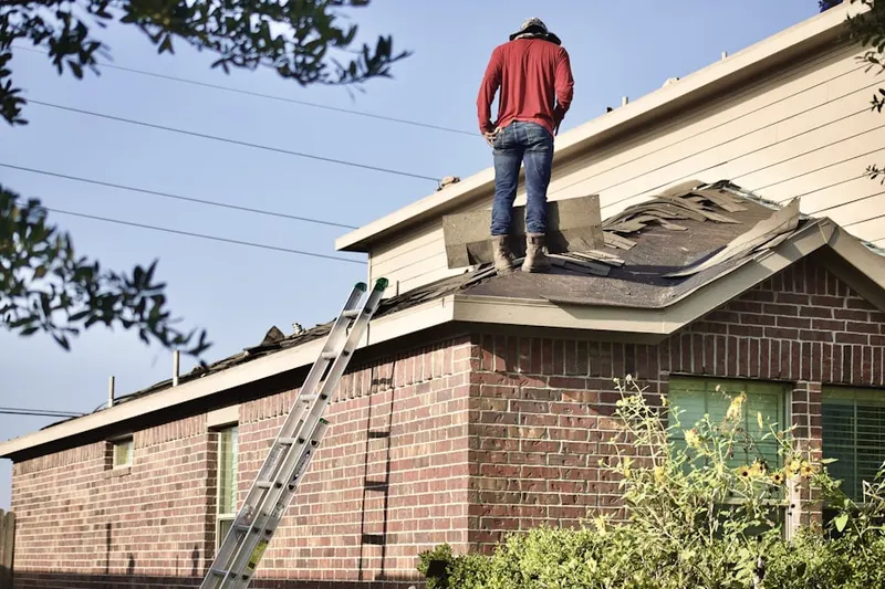 Professional roofer working on a residential roof in Foote Corners